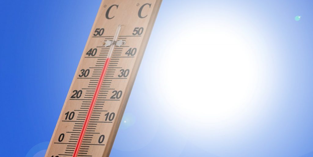 A thermometer under blue sky and bright sunshine