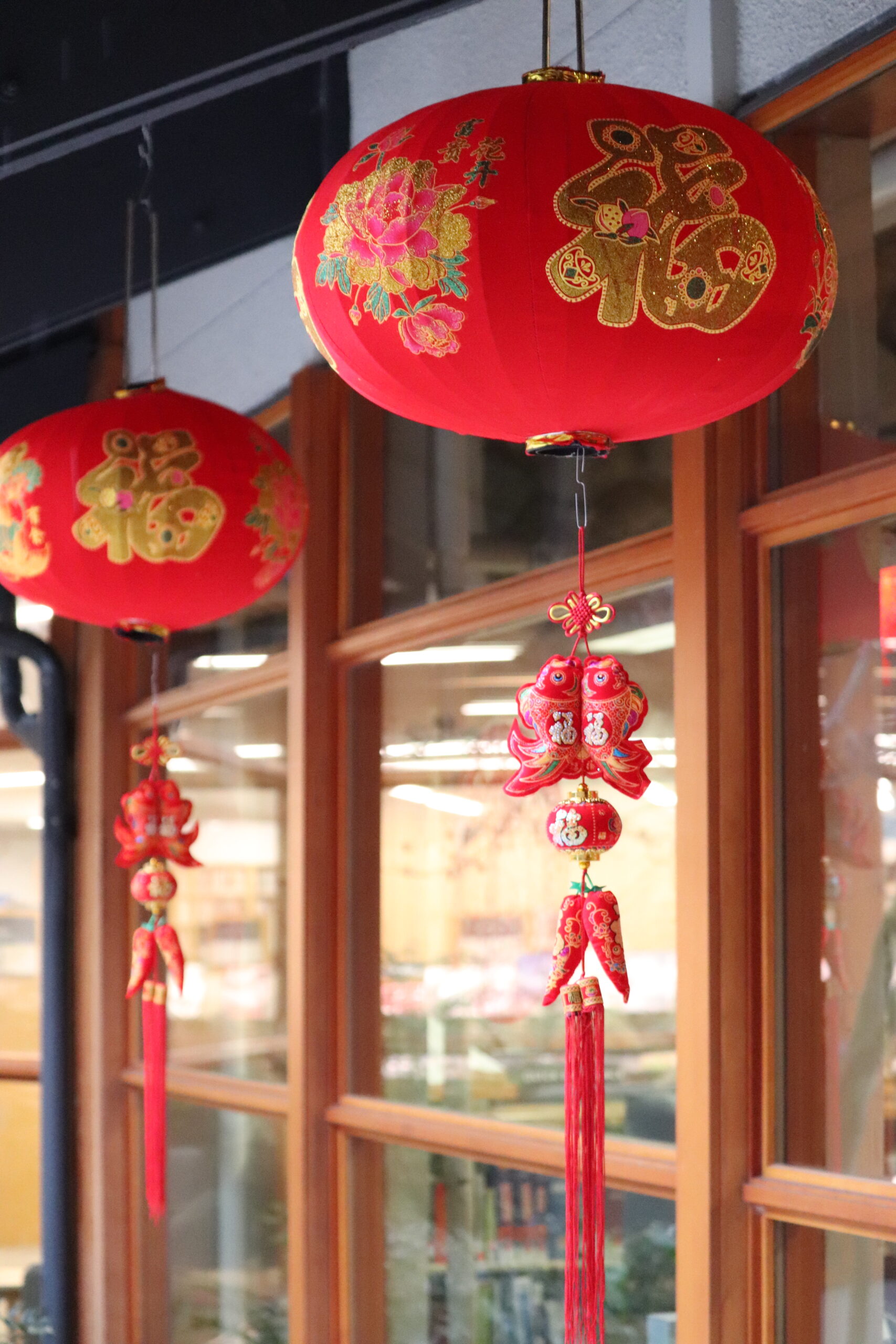 two red Lunar New Year lanterns hang outside the front windows of the Library.