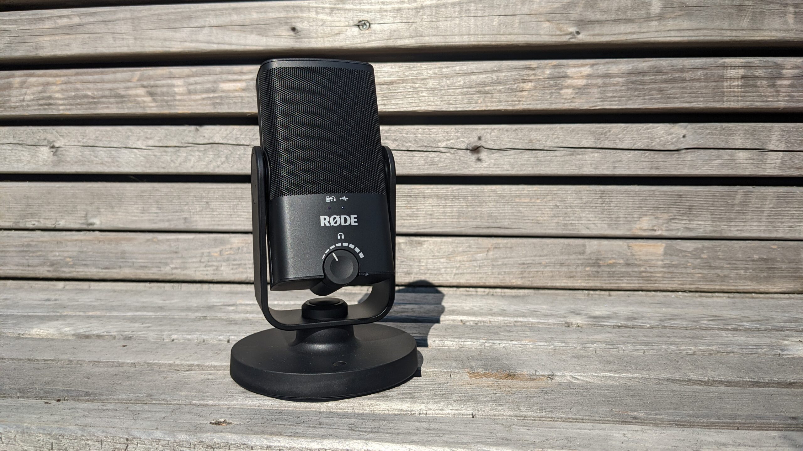 a black microphone sitting on a wood bench