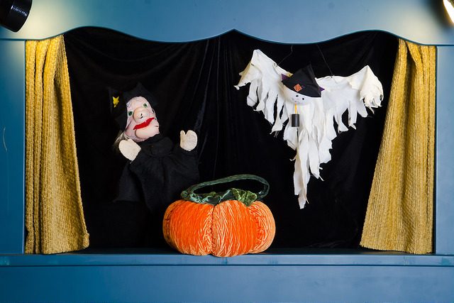 A witch, ghost, and pumpkin on a puppet stage