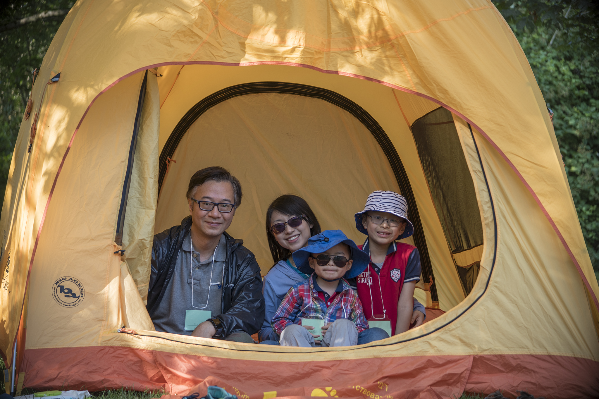 Family of 4 sit in a yellow tent