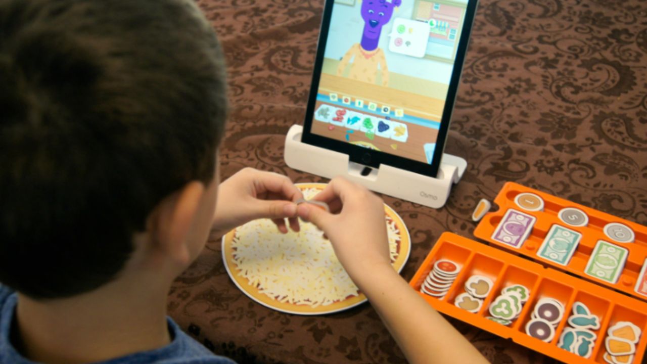 Kid playing Osmo Pizza Co. Game