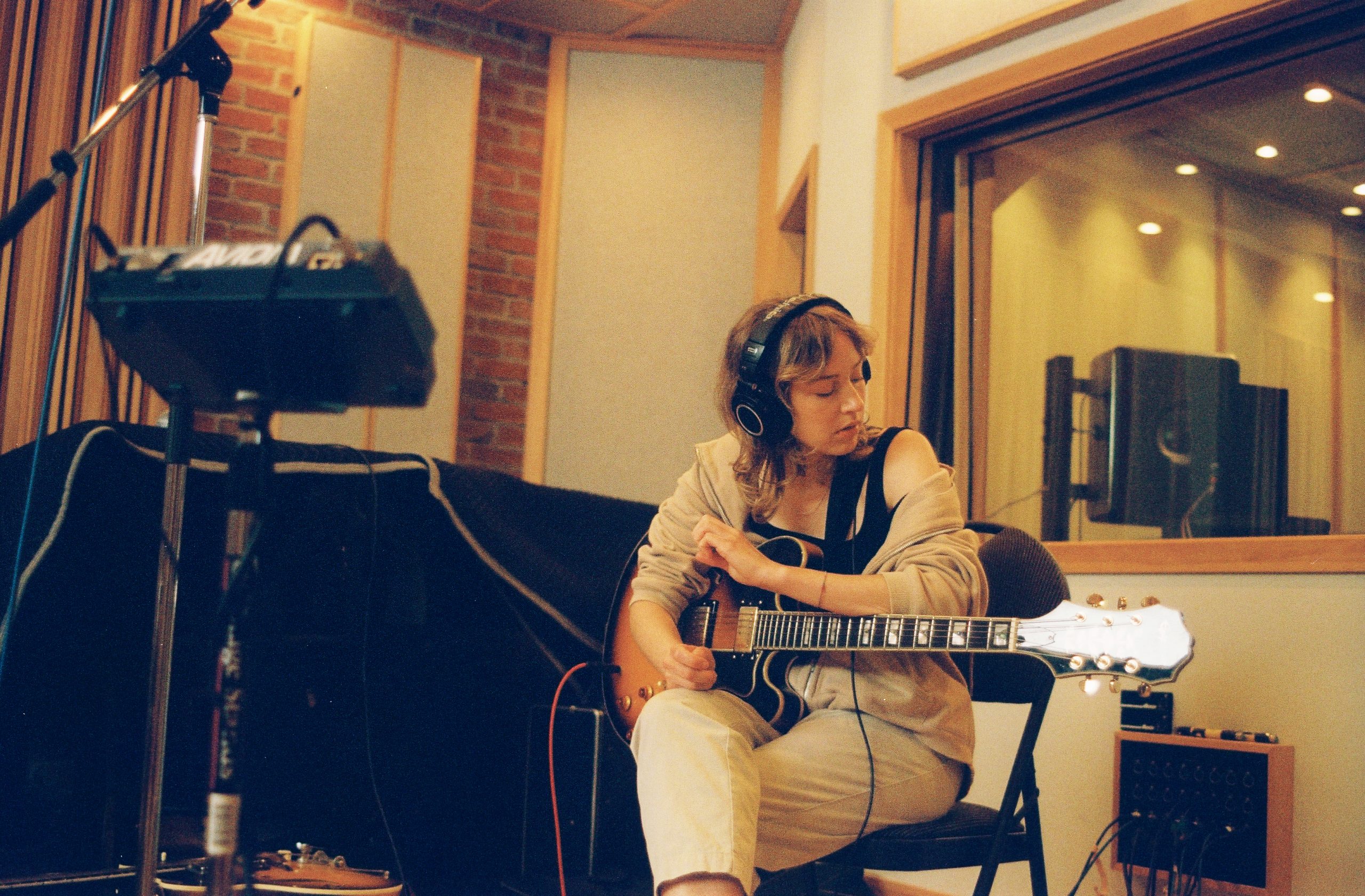 Sam Lynch playing guitar in a recording studio