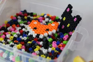 A plastic bucket of Simbrix pieces with a completed fox face and cat face Simbrix creation sitting on top. 