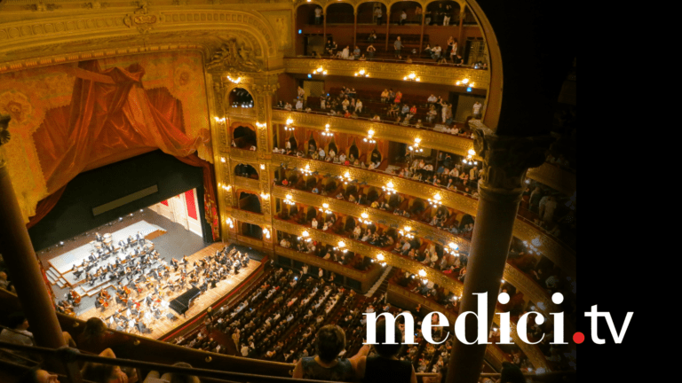 A bird's eye view of a classical concert in a warmly lit opera house. Text "medici.tv" appears in the bottom right.