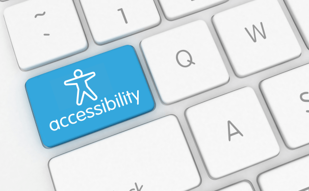 A section of a computer keyboard has a blue key with the universal icon for accessibility.