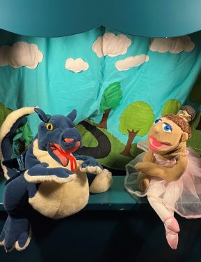 A Dragon and ballet dancer puppet pose on a puppet stage