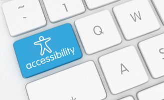 A section of a computer keyboard has a blue key with the universal icon for accessibility.